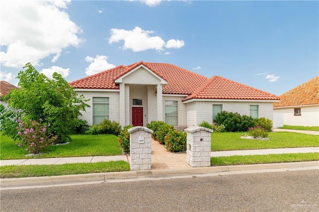 mediterranean / spanish home featuring a front lawn