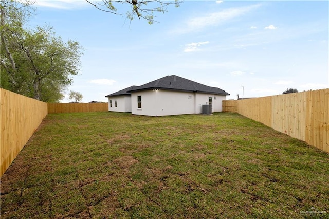 view of yard with central air condition unit and a fenced backyard