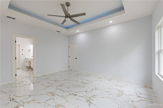 unfurnished bedroom featuring baseboards, visible vents, ensuite bath, a tray ceiling, and marble finish floor