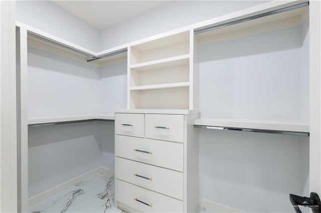 spacious closet featuring marble finish floor