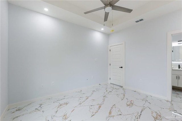 unfurnished room with visible vents, marble finish floor, a tray ceiling, recessed lighting, and baseboards