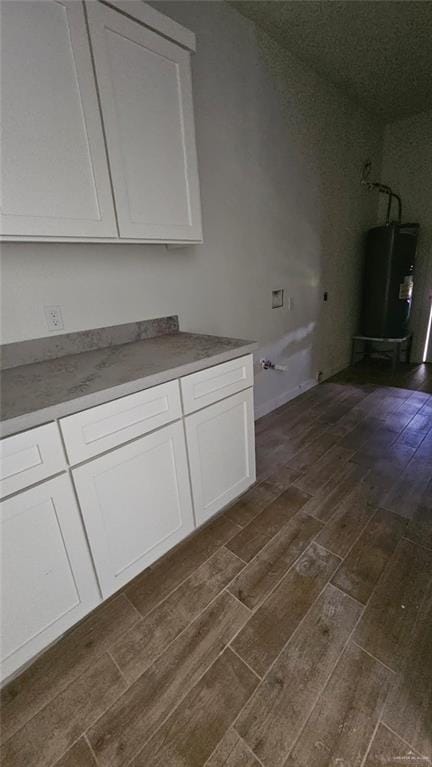 2721 Chesterfield Ave, Edinburg, TX 78539 - kitchen with dark wood finished floors, white cabinets, and water heater