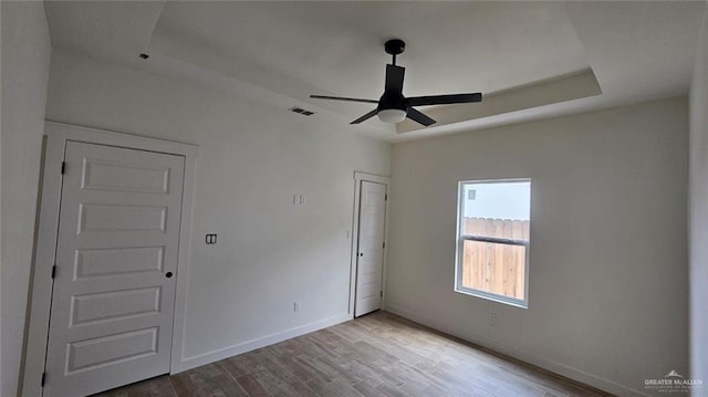2721 Chesterfield Ave, Edinburg, TX 78539 - unfurnished bedroom with wood finished floors, baseboards, a raised ceiling, and a ceiling fan