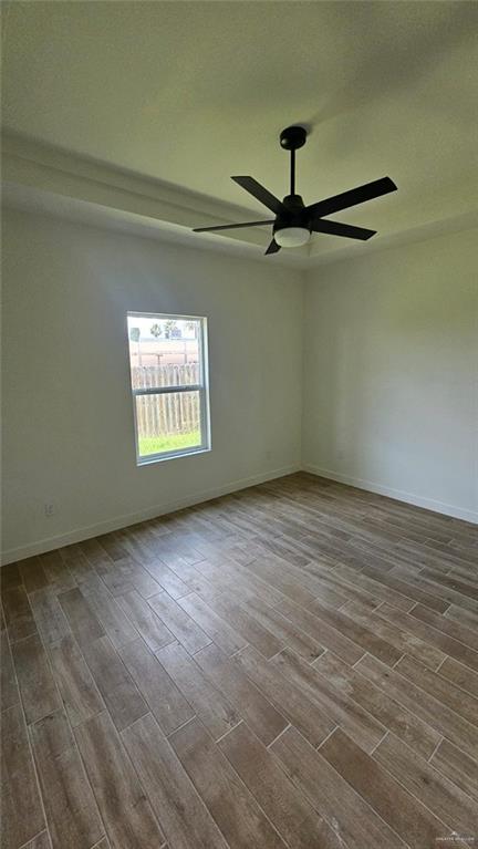 2721 Chesterfield Ave, Edinburg, TX 78539 - empty room with dark wood-style floors, a ceiling fan, and baseboards