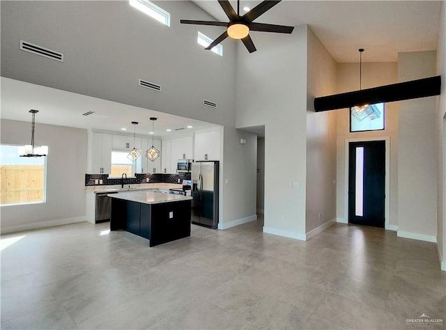 kitchen featuring open floor plan, stainless steel appliances, a kitchen island, and visible vents