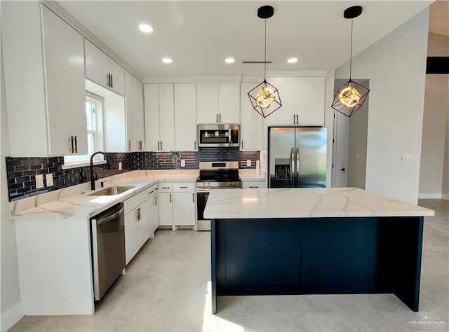 kitchen with a kitchen island, appliances with stainless steel finishes, decorative backsplash, and a sink