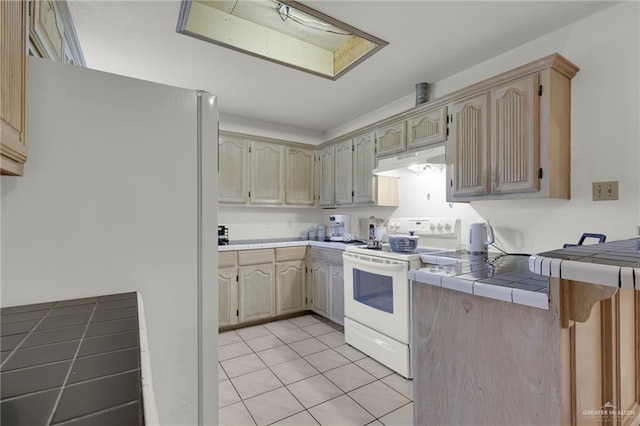 3019 Floresta St, Edinburg, TX 78541 - kitchen featuring white appliances, under cabinet range hood, tile countertops, and light tile patterned floors