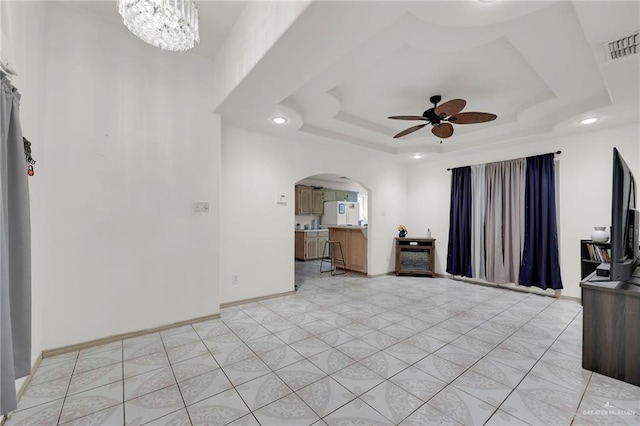 3019 Floresta St, Edinburg, TX 78541 - unfurnished living room with a ceiling fan, arched walkways, recessed lighting, a tray ceiling, and baseboards