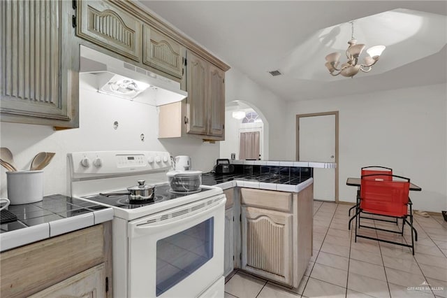 3019 Floresta St, Edinburg, TX 78541 - kitchen with white electric range oven, a peninsula, a chandelier, tile counters, and under cabinet range hood