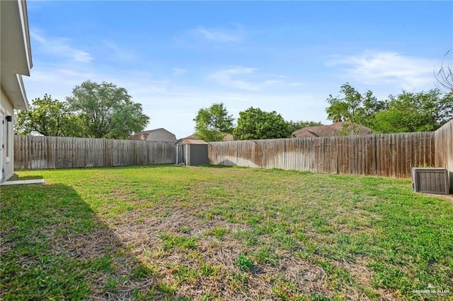 view of yard featuring an outdoor structure, a shed, and a fenced backyard
