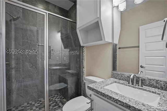 full bath with vanity, toilet, and a stall shower
