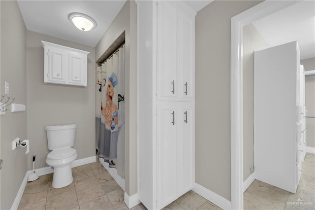 full bathroom with baseboards, marble finish floor, a shower with shower curtain, and toilet