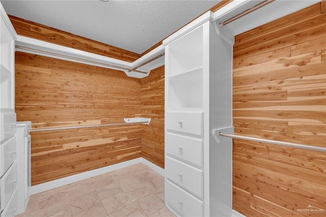 walk in closet with marble finish floor