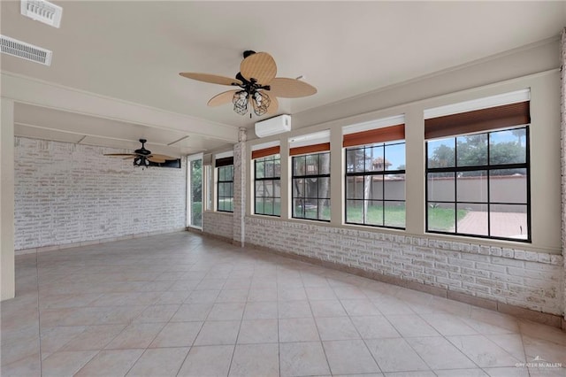 unfurnished sunroom featuring visible vents, a wall mounted air conditioner, and brick wall