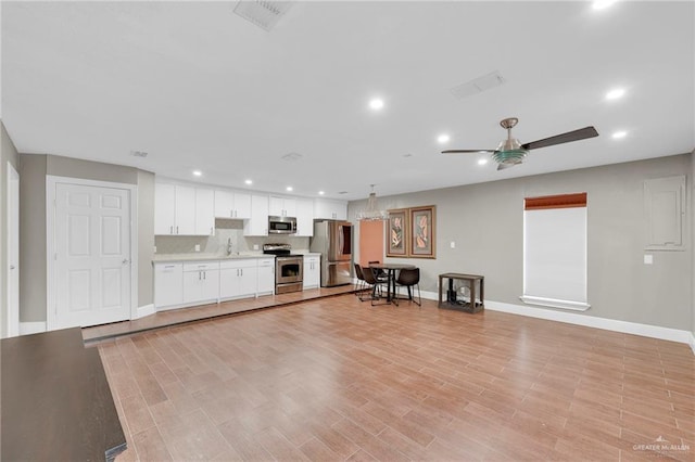 kitchen with a ceiling fan, a sink, baseboards, stainless steel appliances, and recessed lighting