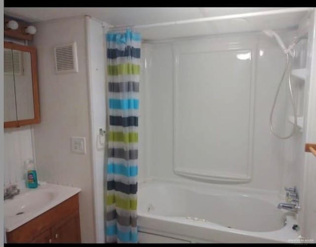 bathroom featuring vanity and shower / bathtub combination with curtain