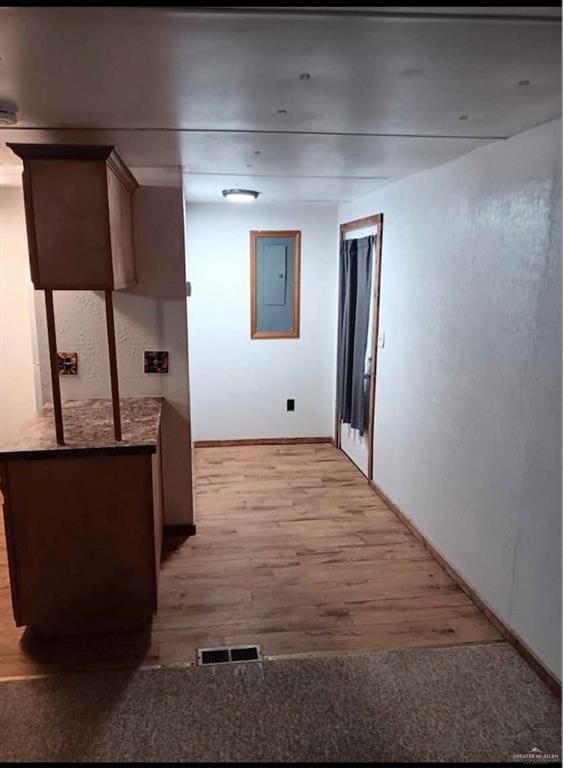 hallway with light hardwood / wood-style flooring and electric panel