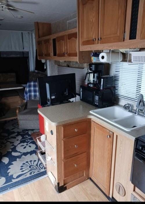 kitchen featuring stove, sink, and light hardwood / wood-style flooring