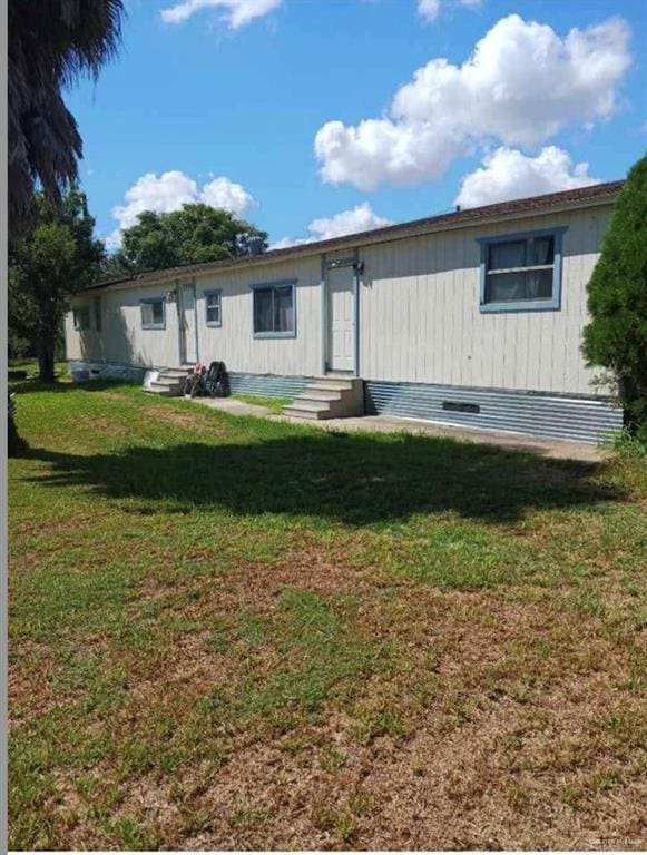 rear view of property featuring a yard