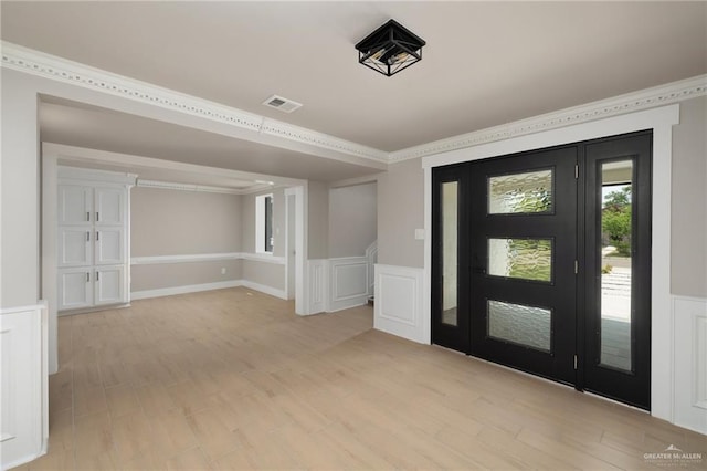 1817 Dolores Del Rio Ave, Mission, TX 78572 - entryway featuring light wood-style floors, ornamental molding, a wainscoted wall, and a decorative wall