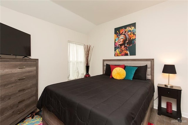 bedroom featuring hardwood / wood-style flooring and vaulted ceiling