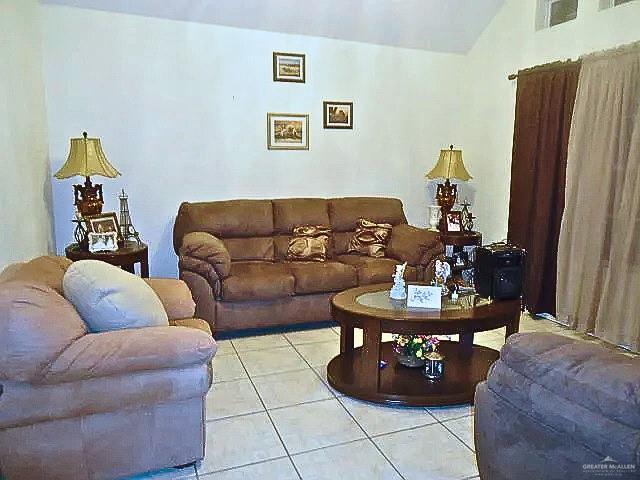 living room with lofted ceiling and light tile patterned floors
