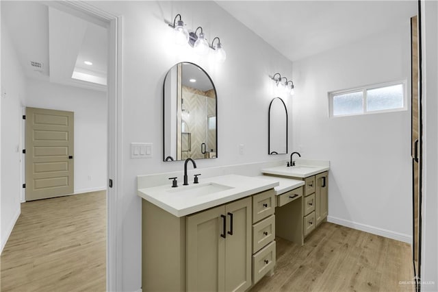 bathroom with a raised ceiling, vanity, and wood-type flooring