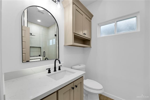 bathroom with vanity, a shower with shower door, and toilet