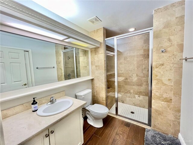 3530 Los Lagos Dr, Edinburg, TX 78542 - full bath featuring wood finished floors, a stall shower, vanity, toilet, and visible vents