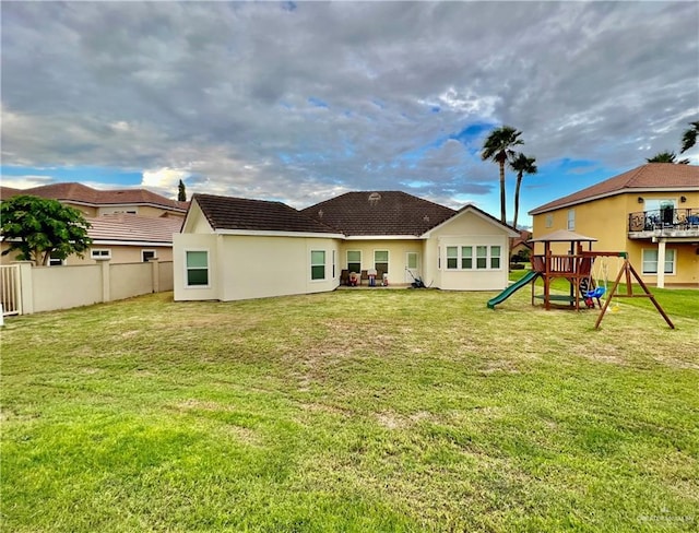 3530 Los Lagos Dr, Edinburg, TX 78542 - rear view of property featuring stucco siding, fence, a yard, and a playground