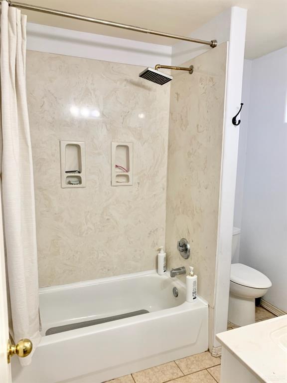 full bathroom with vanity, tile patterned floors, shower / bath combination with curtain, and toilet