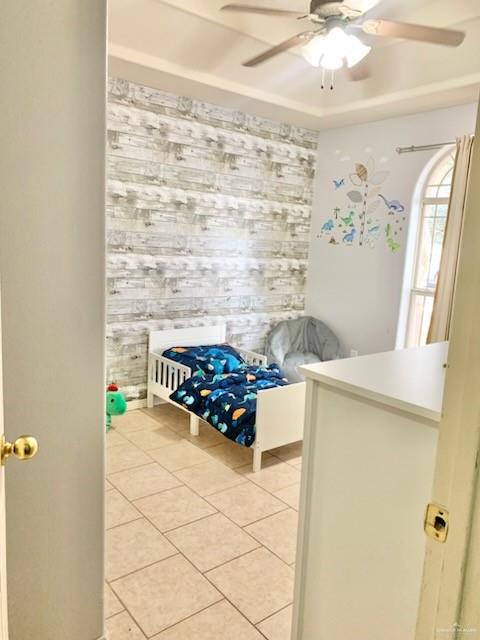 bedroom featuring light tile patterned floors and ceiling fan