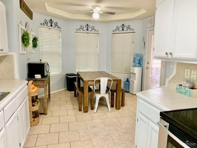 dining area featuring a tray ceiling and ceiling fan