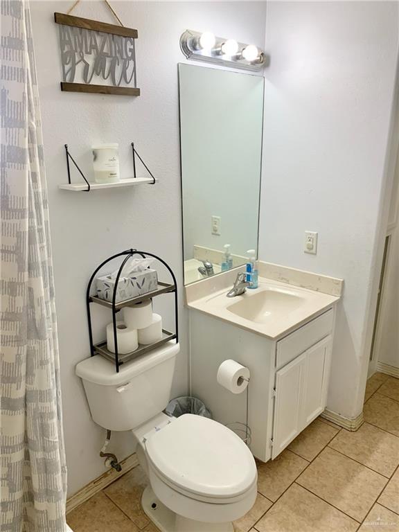 bathroom featuring tile patterned flooring, vanity, and toilet