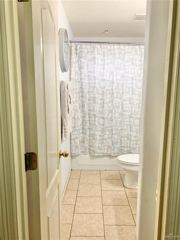 bathroom with tile patterned flooring, toilet, and shower / bathtub combination with curtain