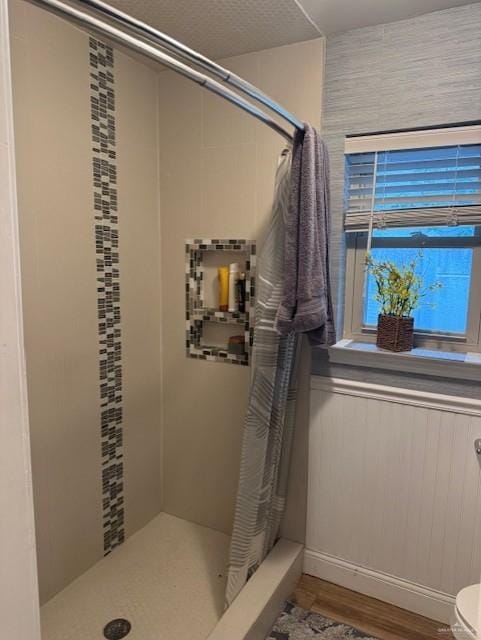 bathroom featuring curtained shower, wood-type flooring, and toilet