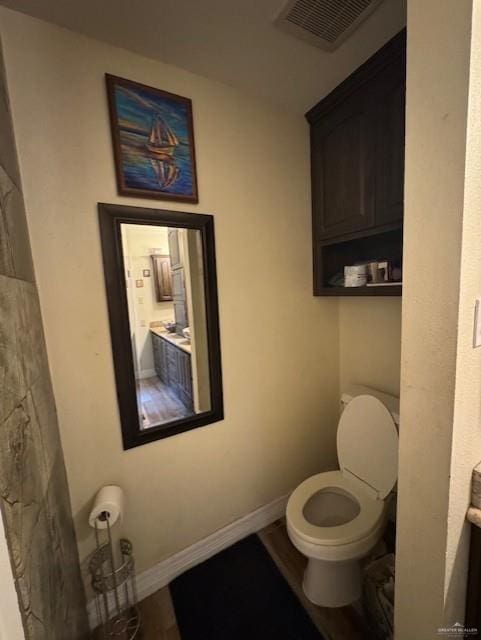 bathroom with wood-type flooring and toilet