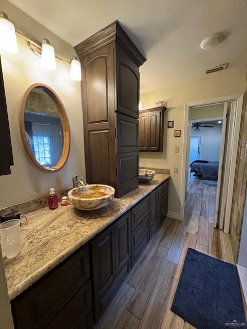 bathroom with ceiling fan, vanity, and wood-type flooring