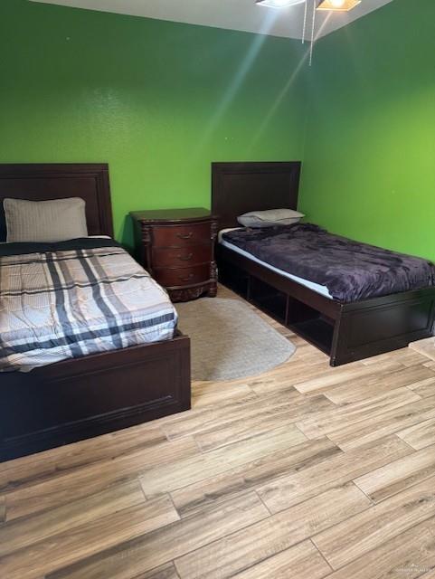 bedroom with light hardwood / wood-style floors and ceiling fan