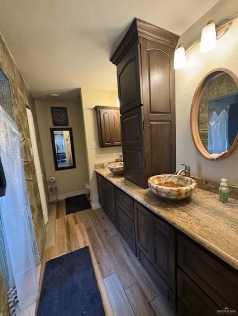 bathroom with vanity, toilet, wood-type flooring, and walk in shower