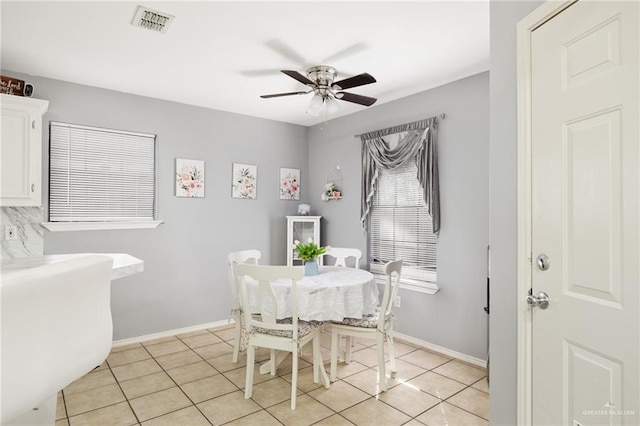 dining area with visible vents, baseboards, ceiling fan, and light tile patterned floors