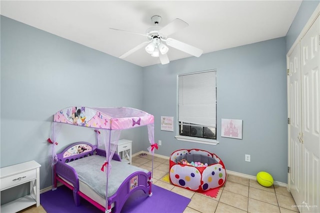 tiled bedroom featuring ceiling fan, baseboards, and a closet
