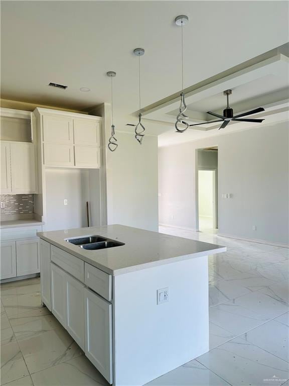 kitchen with marble finish floor, pendant lighting, white cabinets, and a center island