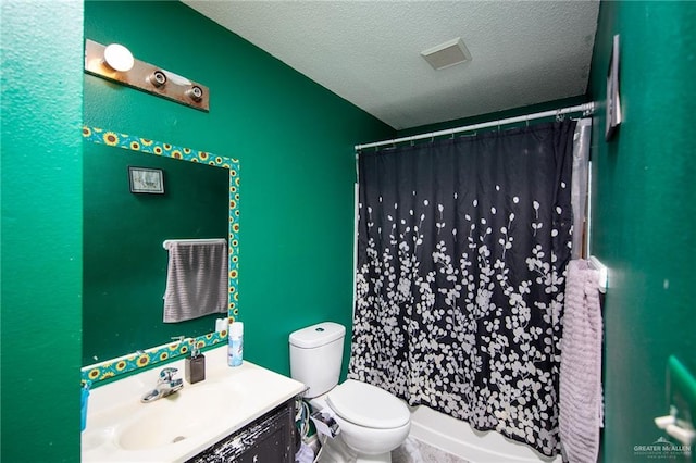 bathroom with vanity, toilet, and a textured ceiling