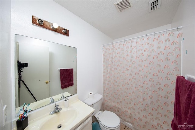 bathroom featuring vanity, a textured ceiling, and toilet