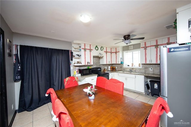 dining area with ceiling fan, sink, and light tile patterned flooring