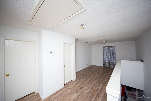 interior space with ceiling fan, wood-type flooring, and a textured ceiling