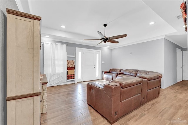 living room with light hardwood / wood-style floors, ceiling fan, and ornamental molding