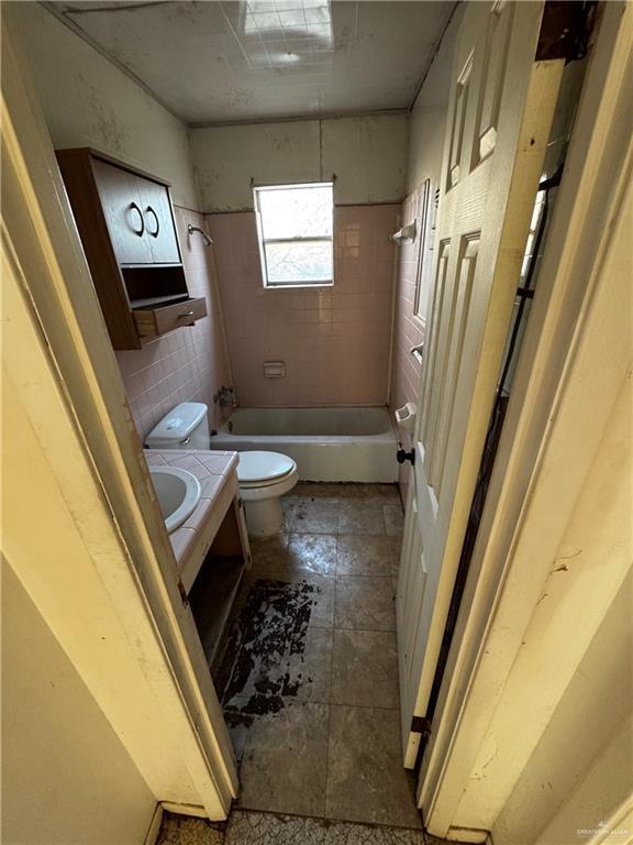 full bathroom featuring tiled shower / bath, vanity, and toilet