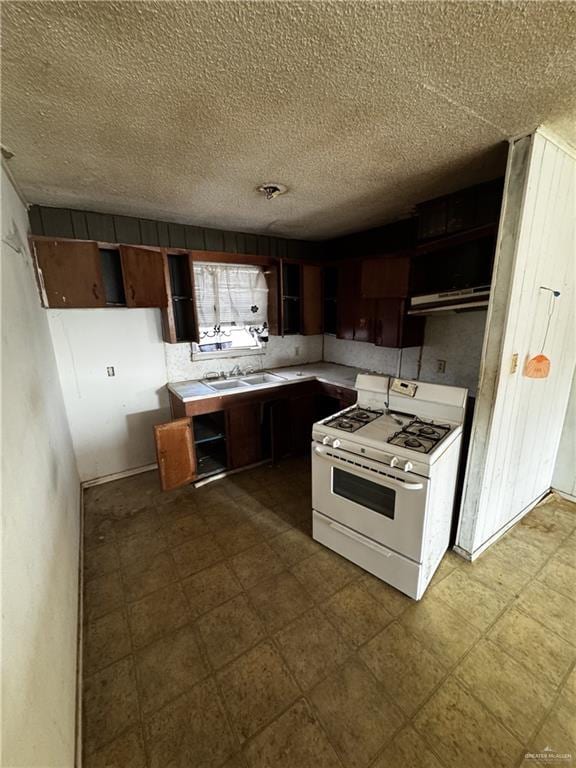 kitchen with sink, a textured ceiling, dark brown cabinetry, and gas range gas stove